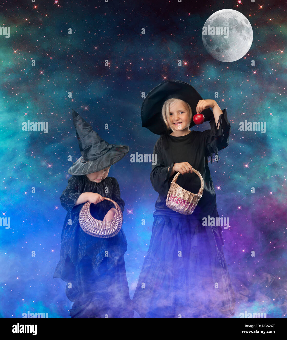 two little halloween witches, background with stars, space and moon Stock Photo