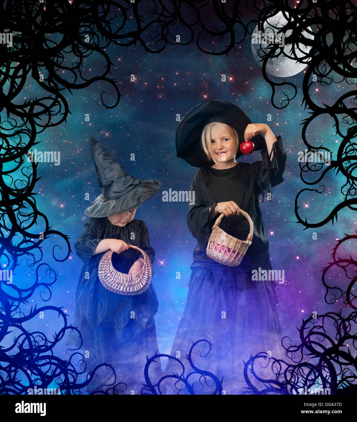 two little halloween witches, background with stars, space and moon Stock Photo