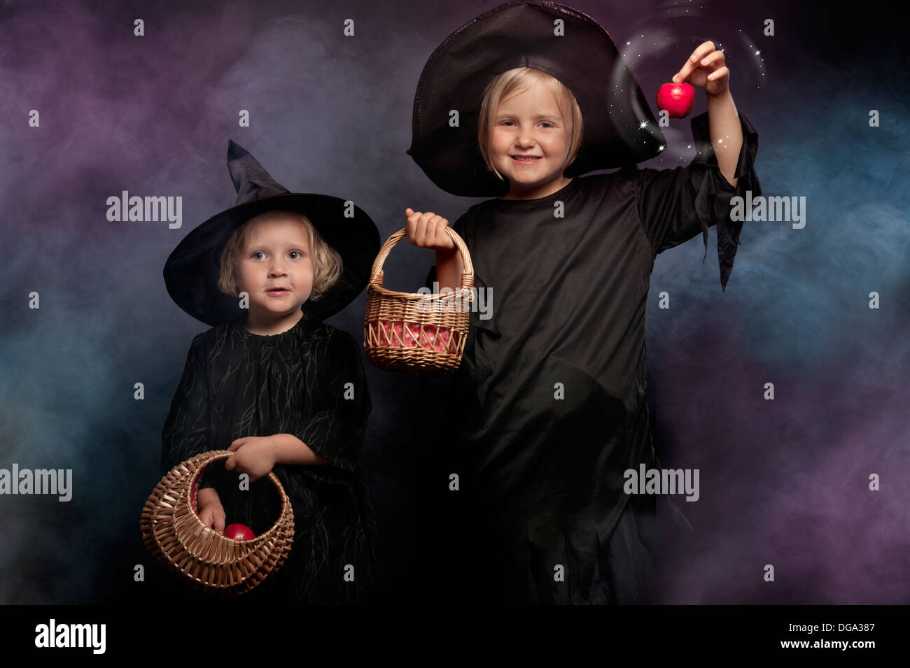 two little halloween witches, colorful smoky background Stock Photo
