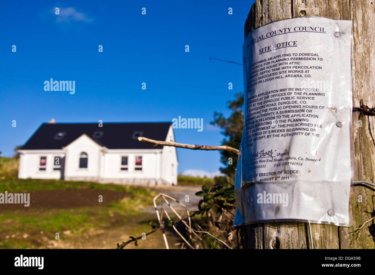 Site Notice indicating intention to apply for planning permission in County Donegal Ireland and new home in background Stock Photo