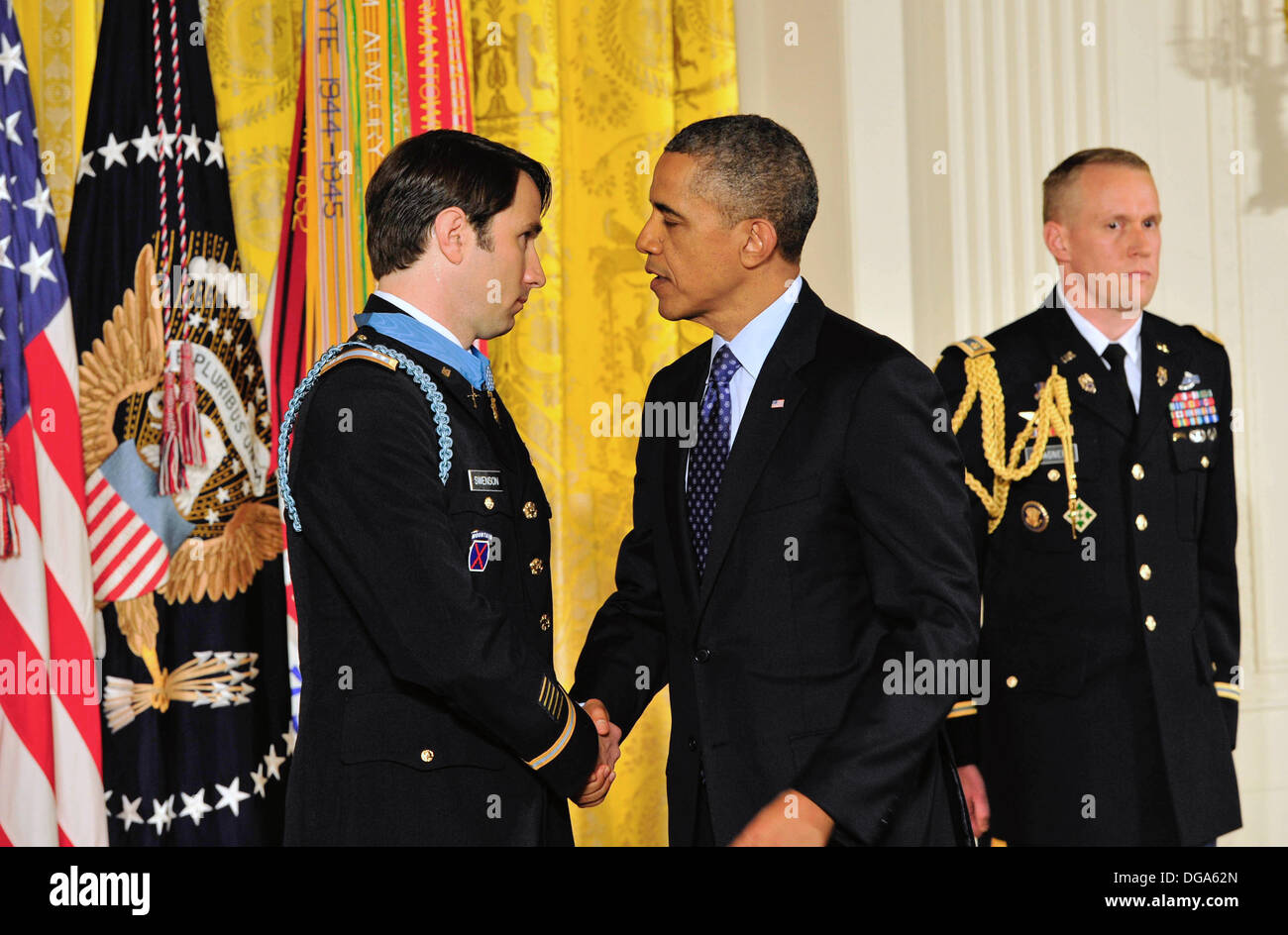 US President Barack Obama congratulates former US Army Capt. William D. Swenson after presenting him with the Medal of Honor during a ceremony in the East Room of the White House October 15, 2013 in Washington, DC. The Medal of Honor is the nation's highest military honor. Stock Photo