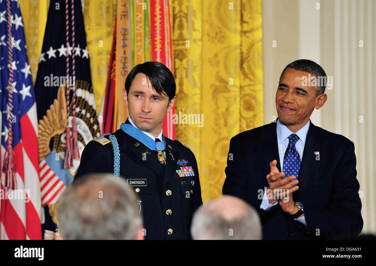 US President Barack Obama applauds former US Army Capt. William D. Swenson after presenting him with the Medal of Honor during a ceremony in the East Room of the White House October 15, 2013 in Washington, DC. The Medal of Honor is the nation's highest military honor. Stock Photo