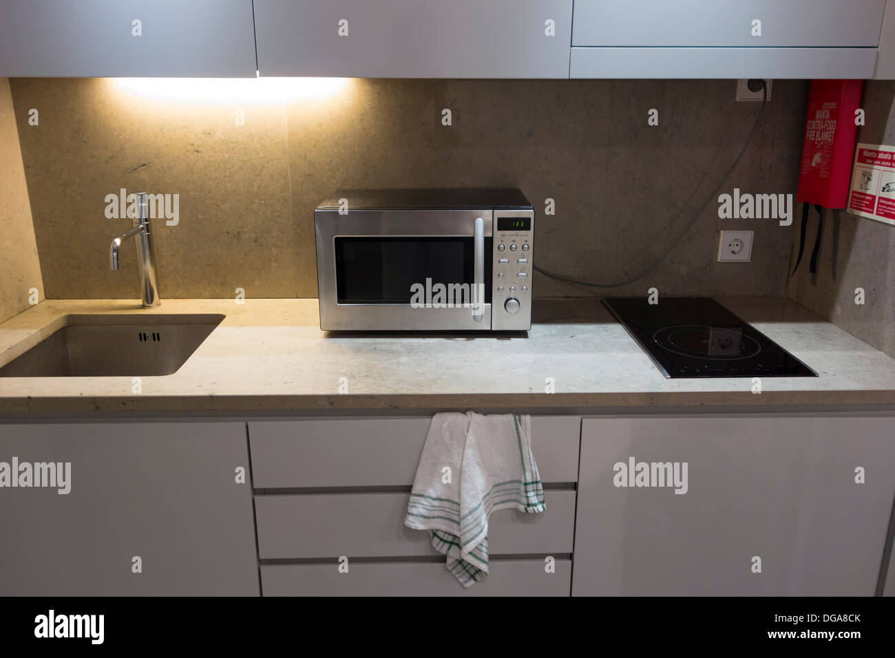 Small modern white kitchen counter with microwave oven Stock Photo