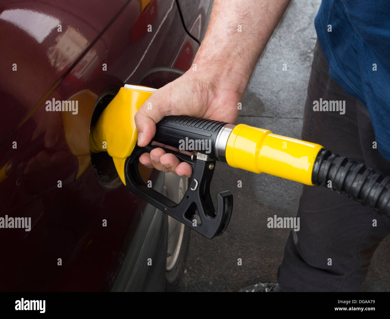 Person pumping gas at a gas station Stock Photo