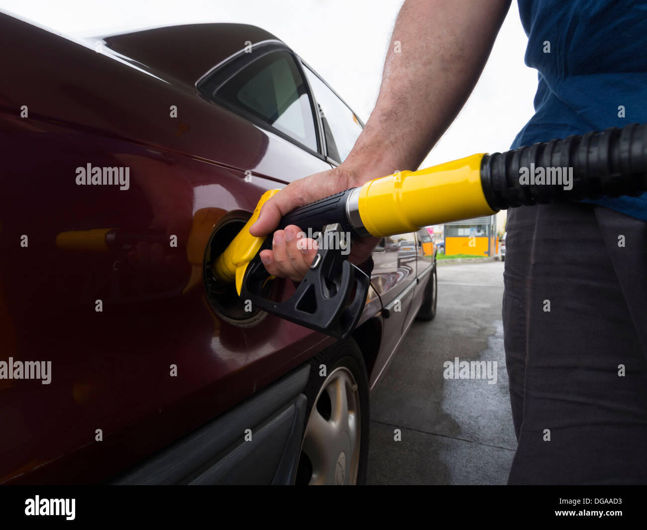 Person pumping gas at a gas station Stock Photo