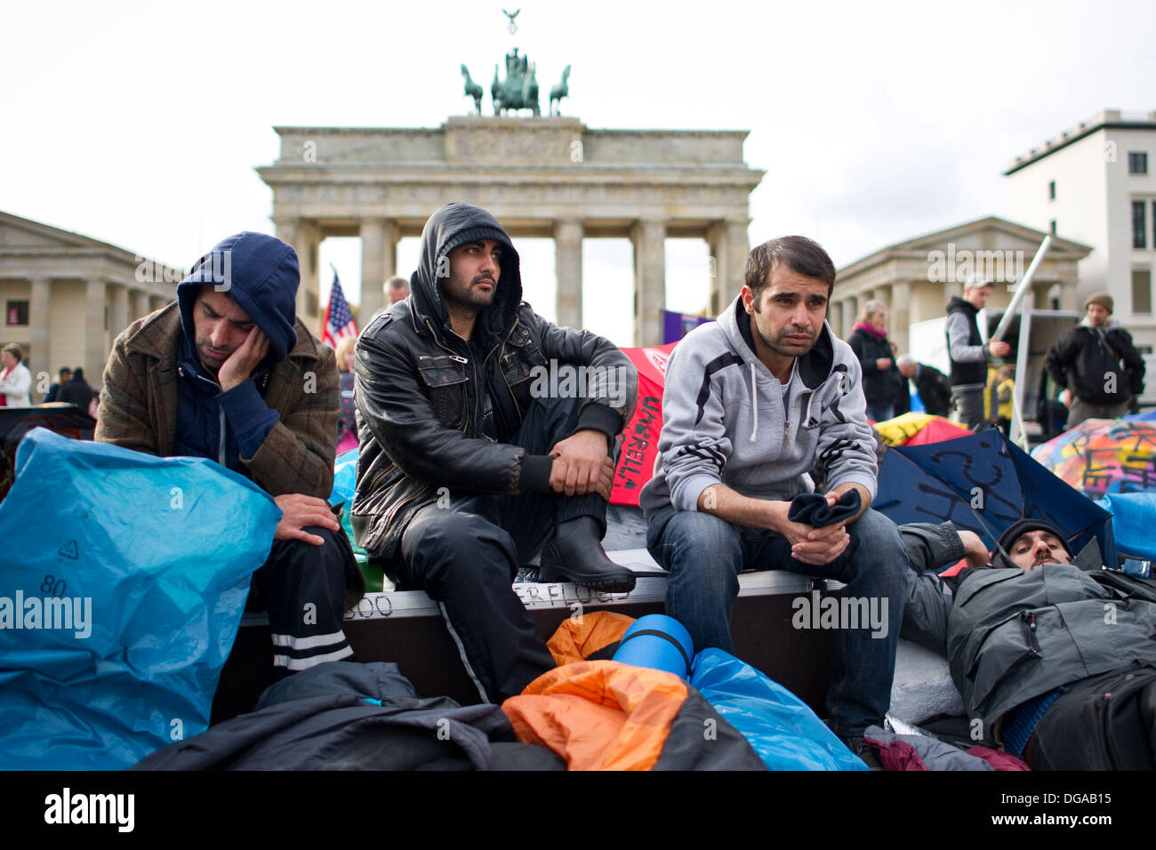 Berlin, Germany. 17th Oct, 2013. Refugees sit on Pariser Platz in front of the Brandenburg Gate in Berlin, Germany, 17 October 2013. Several refugees had to be brought to hospital because of their bad health condition. Since 09 October 2013, the refugees are on a hunger strike. Photo: Ole Spata/dpa/Alamy Live News Stock Photo