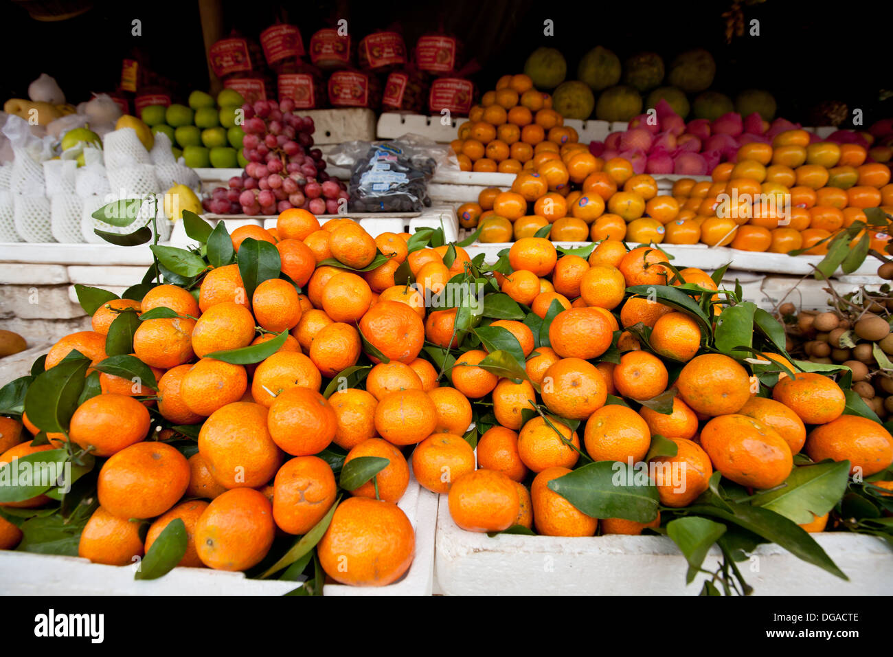 A local street  market filled selling produce, fruits including tangerines piled in heap on table in Siem Reap, Cambodia Stock Photo