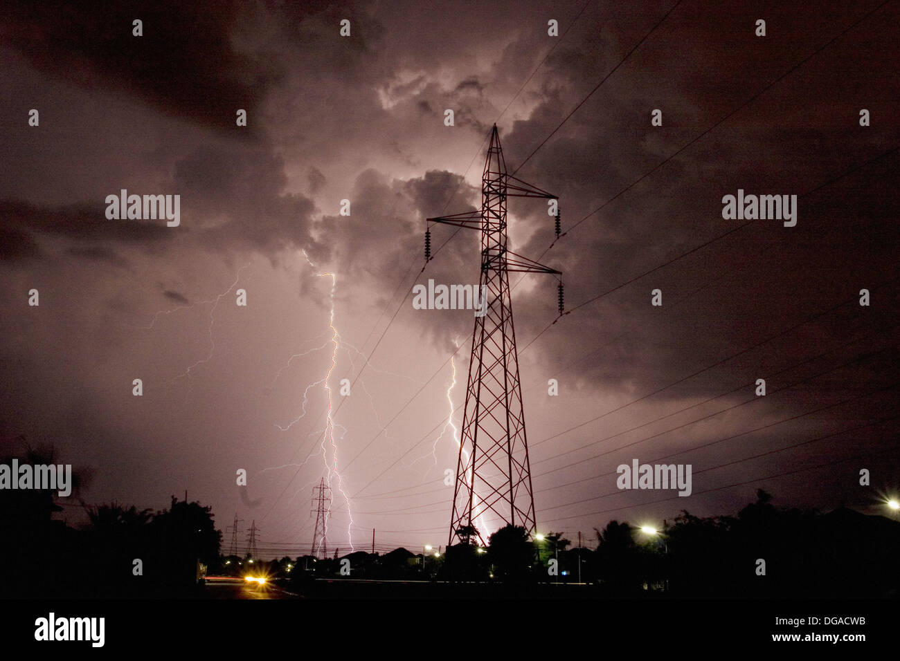 Lightning strikes during thunder storm over a power line Stock Photo