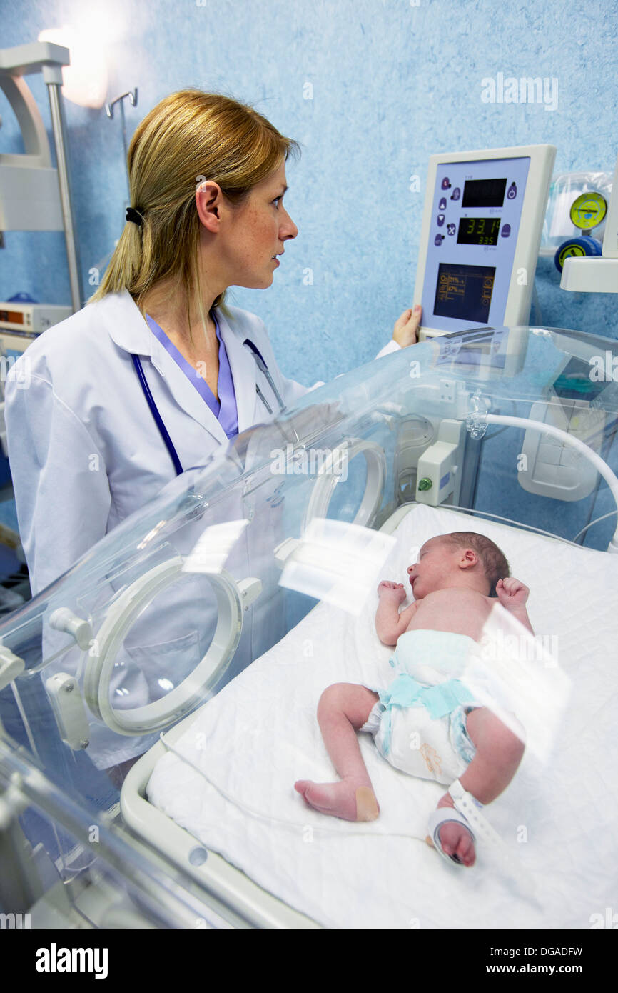 Pediatrician with newborn baby in incubator, pediatrics. Hospital Stock