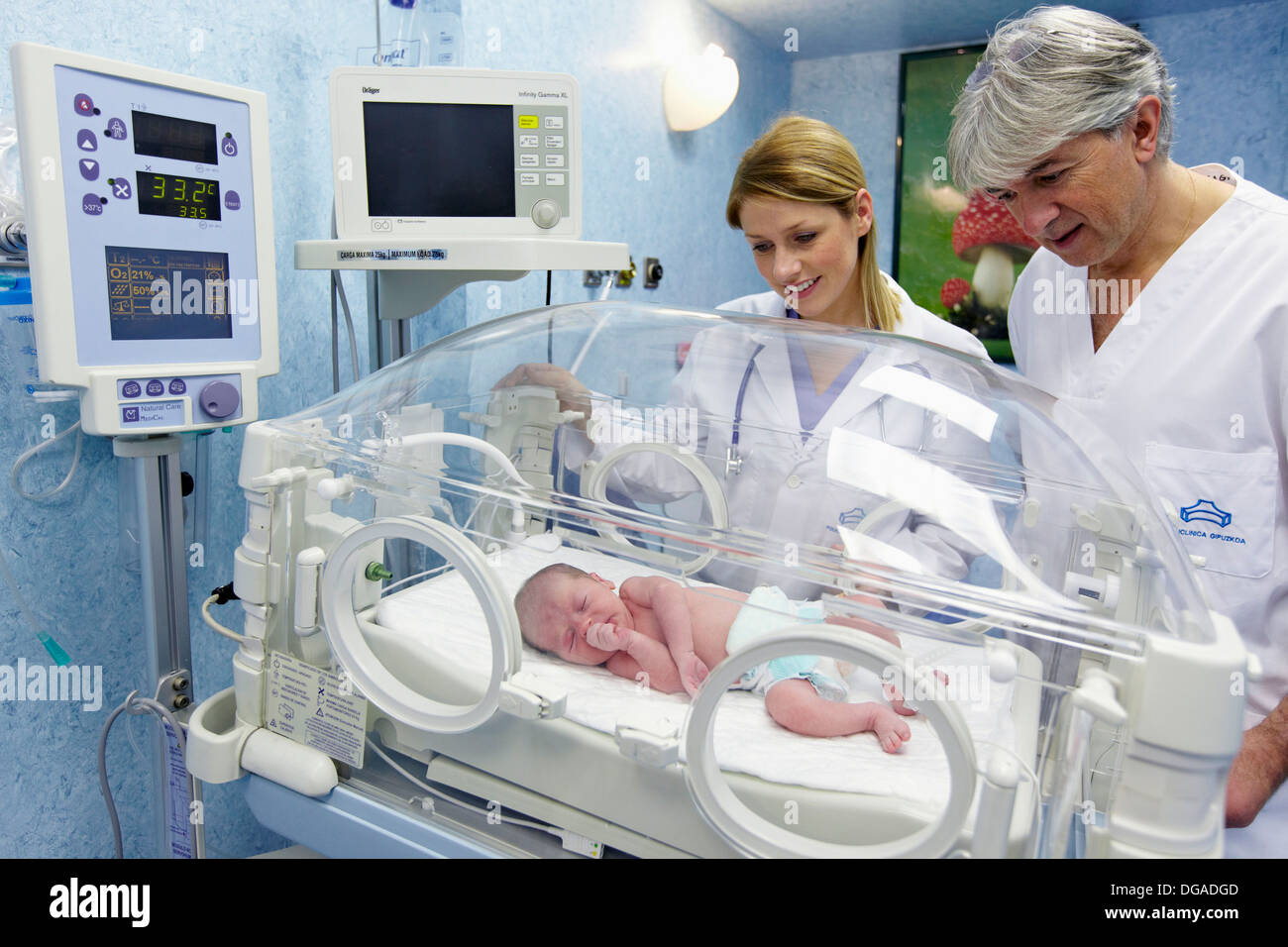 Pediatricians with newborn baby in incubator, pediatrics. Hospital