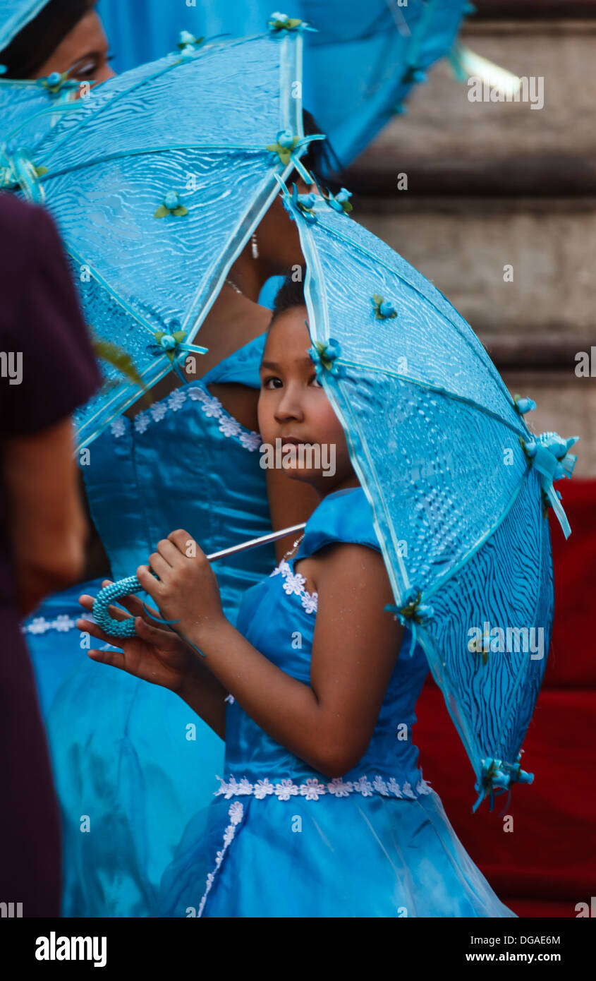 Young bridesmaid in turquoise blue dress peaks out from under matching  parasol during wedding in Granada Nicaragua Stock Photo - Alamy
