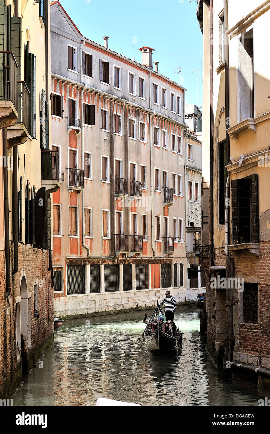 Vertical image of a canal with a gondola sailing by in Venice, Italy Stock Photo