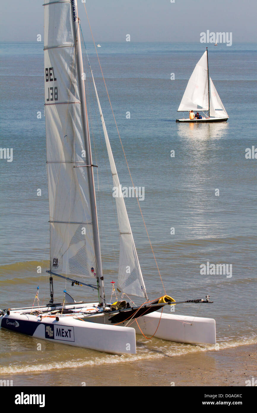 Sailing boat and beached catamaran on beach along the North Sea coast Stock Photo