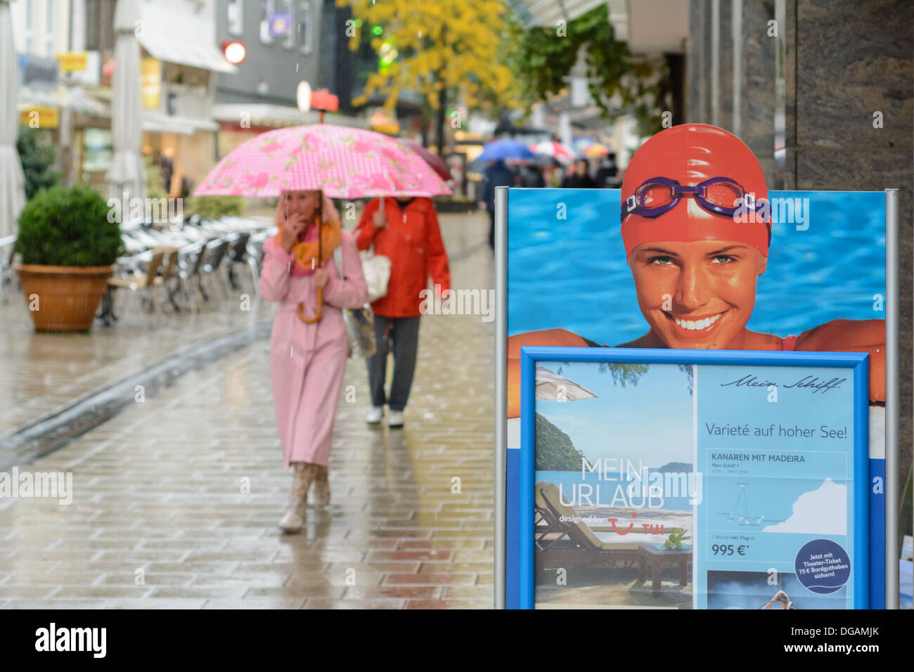 Advertising poster pretty woman with swimming cap and swim goggles and woman with pink umbrella, pink dress walking in the rain Stock Photo