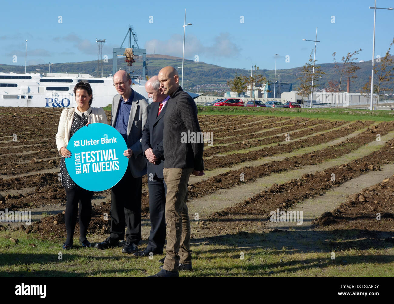 Belfast, Northern Ireland, UK. 17th October 2013. Jorge Rodrigues-Gerada, Artist (right) and Richard Wakely, Festival Director, (2nd from left) pose in front of giant artwork 'Wish', Titanic Quarter Credit:  J Orr/Alamy Live News Stock Photo