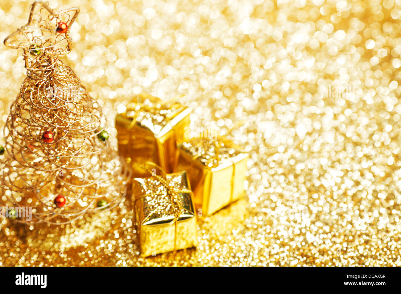 Golden christmas fir tree decoration and gifts on glitter background ...