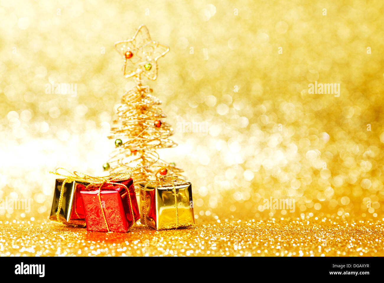 Golden christmas fir tree decoration and gifts on glitter background ...