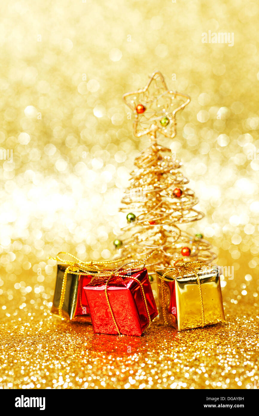 Golden christmas fir tree decoration and gifts on glitter background ...