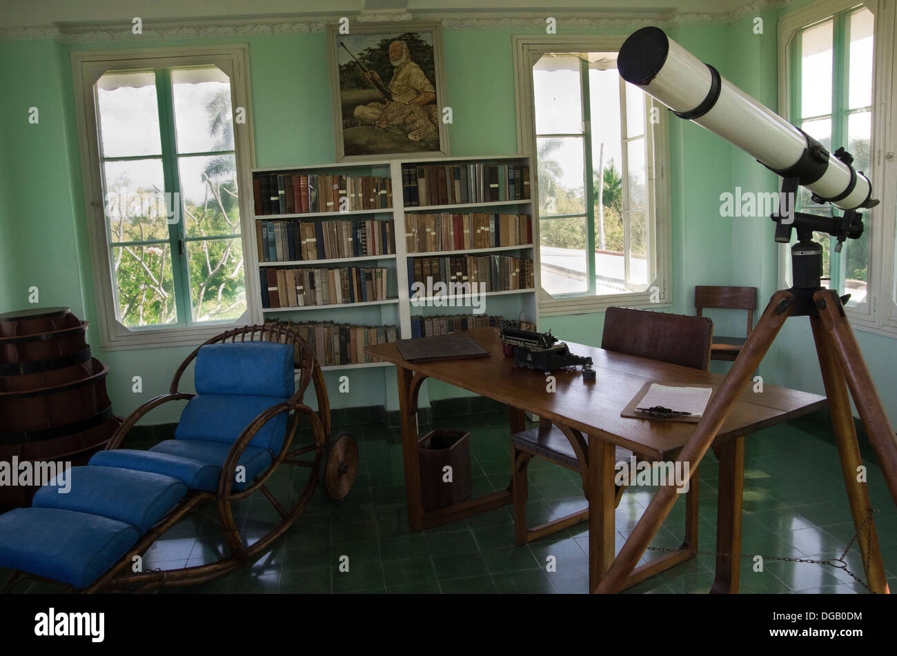 Hemmingway's house, writing room upstairs, desk, typewriter, and portrait of Hemmingway with leopard kill on his knee Stock Photo