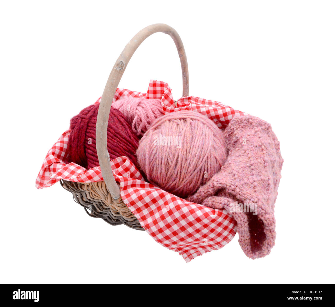 Pink and red balls of wool with patterned knitting in a basket, isolated on a white background Stock Photo