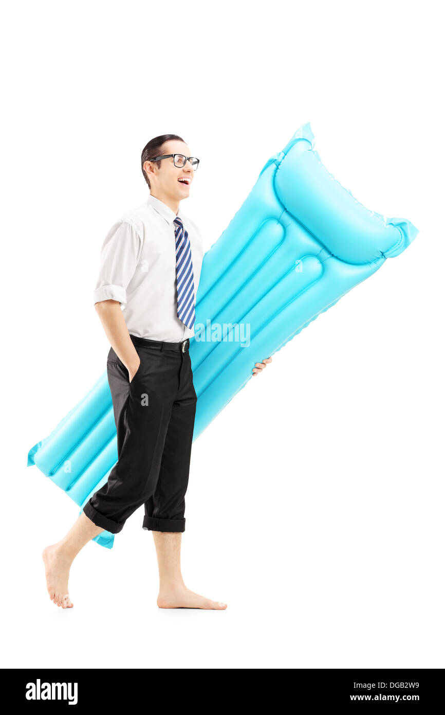 Full length portrait of a smiling barefooted man on vacation holding a swimming mattress Stock Photo