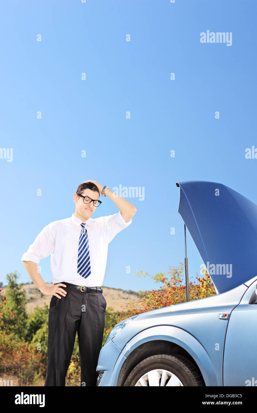 Confused man near a broken car thinking what to do Stock Photo