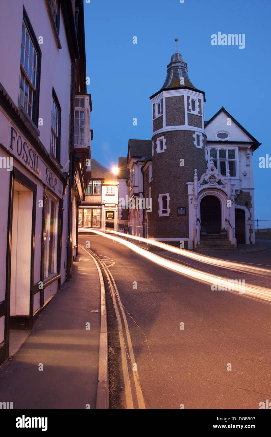 Jurassic Coast. The quaint historic Lyme Regis Guildhall. Car lights are streaking along the narrow and winding Bridge Street. Dorset, England, UK. Stock Photo