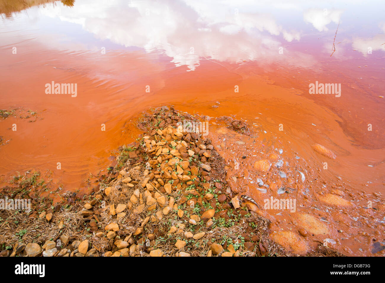 Cloud reflected in contaminated mine effluent from water draining out of wheal Jane, an abandoned tin mine near Redruth, Cornwall, UK. Stock Photo