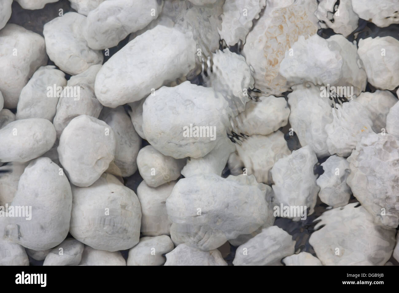 A picture of a bunch of white stones in shallow water Stock Photo