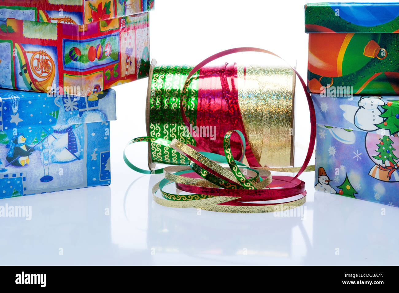 Christmas gifts with red, green and gold ribbon on spool in center ...