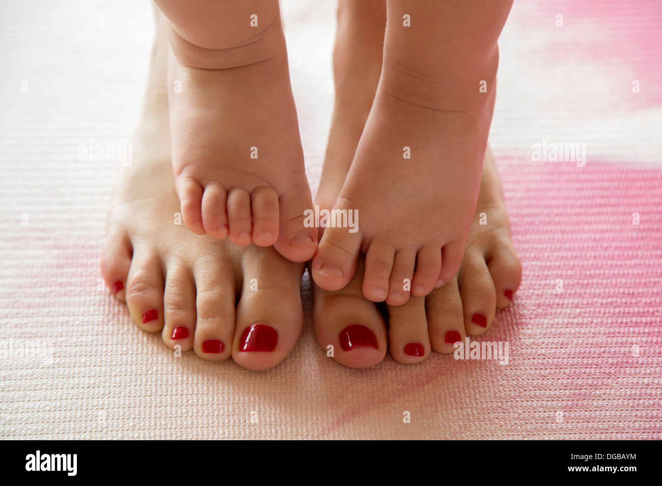 Baby toes on her mother's feet Stock Photo