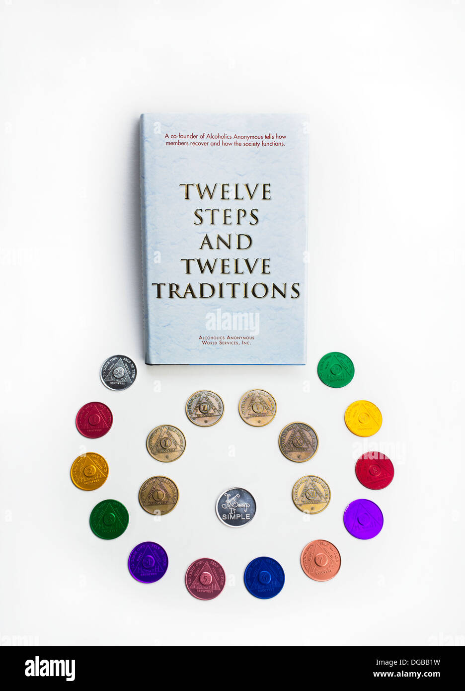 Alcoholics Anonymous AA Book 'The Twelve Steps and Twelve Traditions' with progress coins Stock Photo