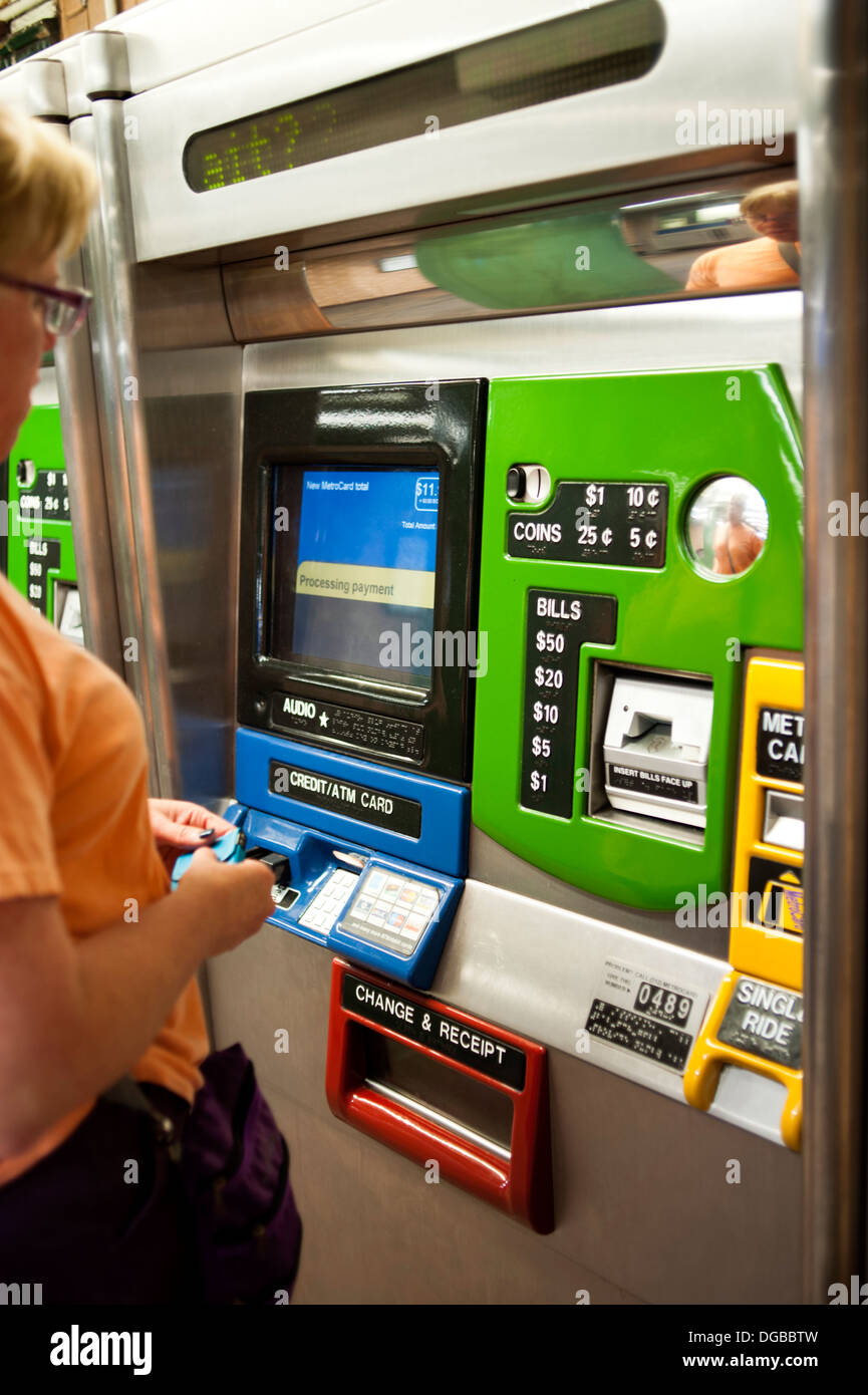 A lady purchasing subway tickets from a kiosk for the New York City subway. Stock Photo