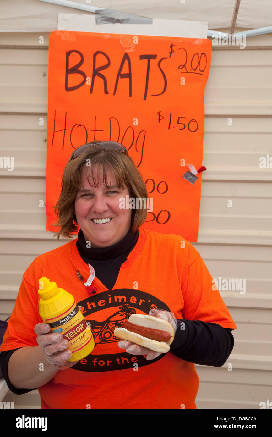 Happy woman selling brats at an outdoor food stand. Pierz Minnesota MN USA Stock Photo