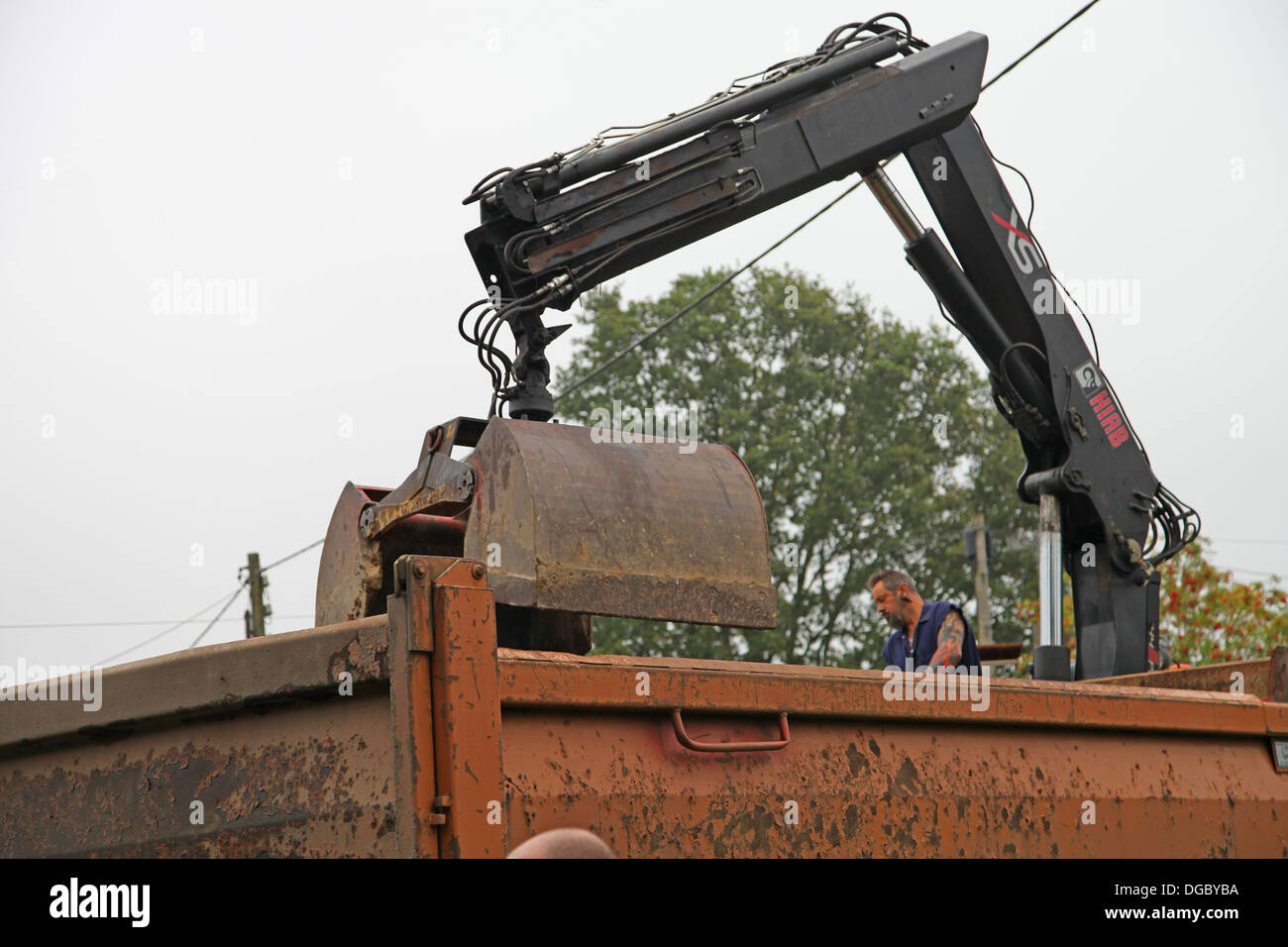 Grab lorry clearing broken up tarmac ready for a new drive Stock Photo