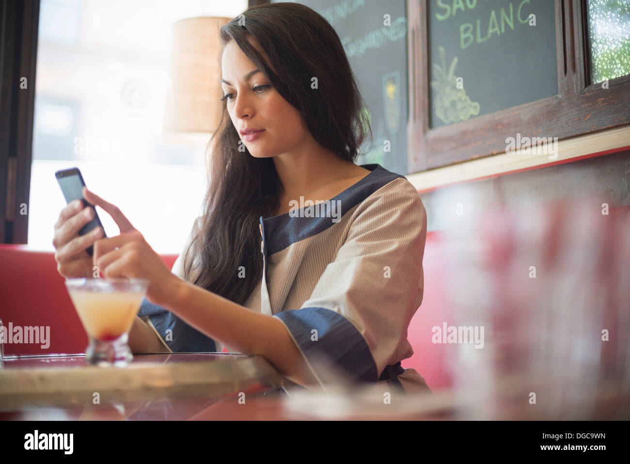 Mid adult women using mobile phone in restaurant Stock Photo