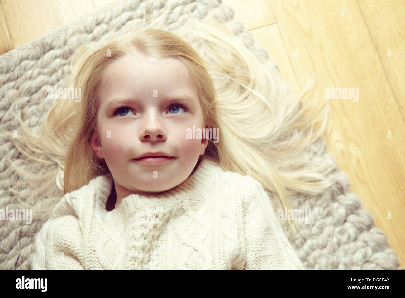 Young girl lying on rug Stock Photo Alamy