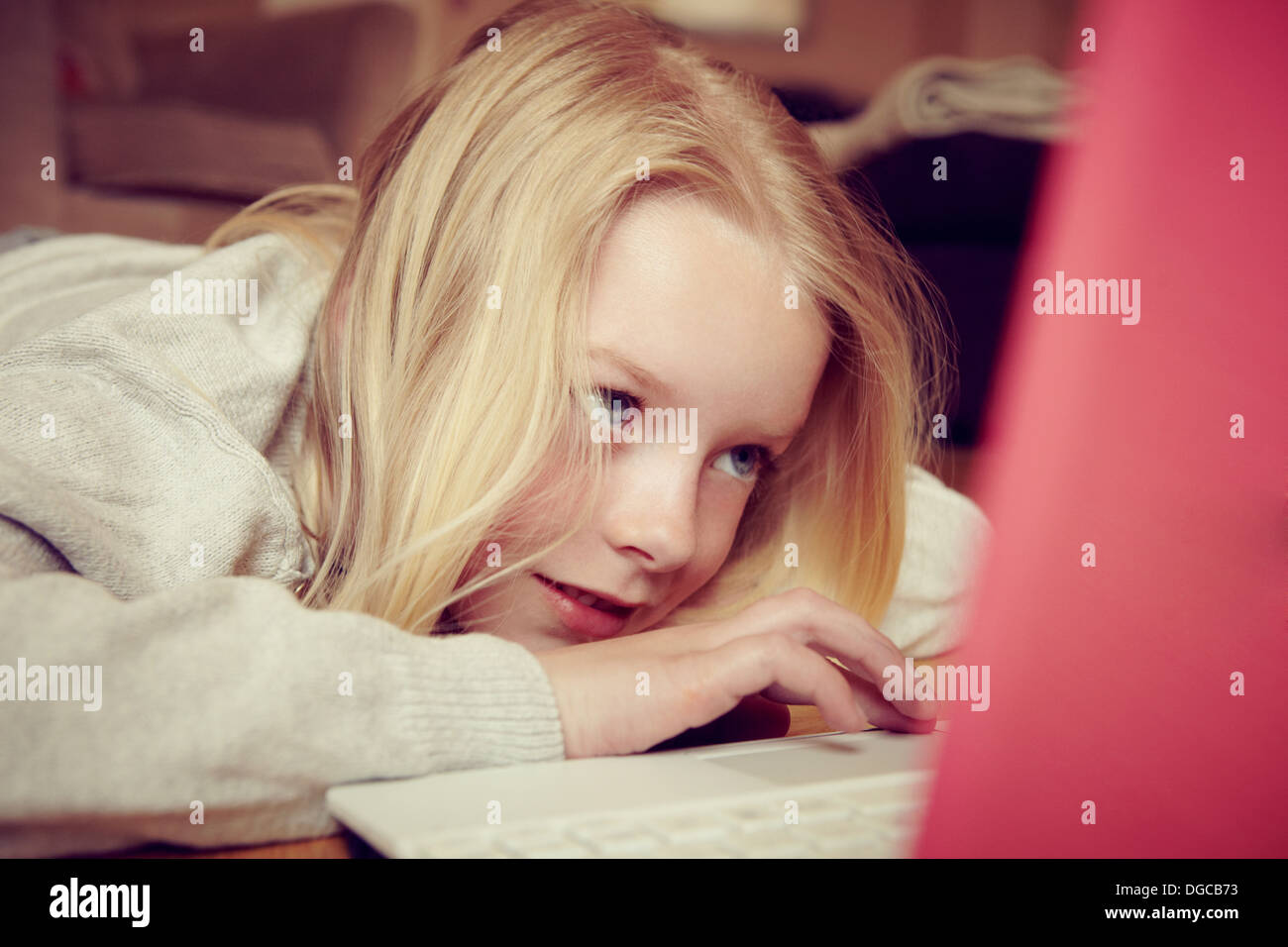 Young girl lying on floor using laptop Stock Photo - Alamy