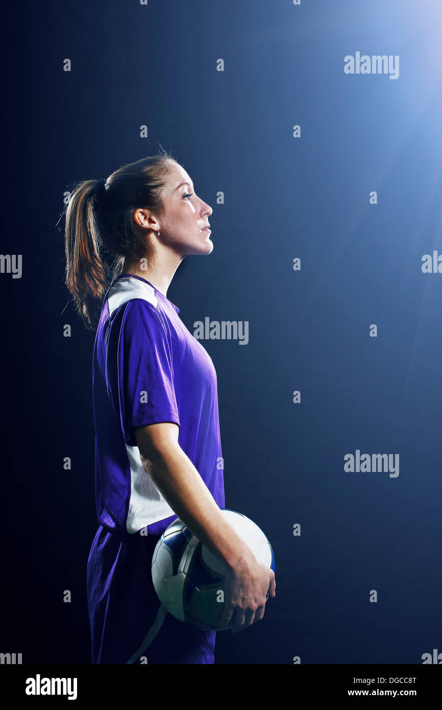 Studio shot of female soccer player holding ball Stock Photo