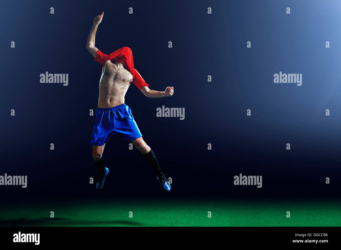 Male soccer player celebrating with shirt over head Stock Photo