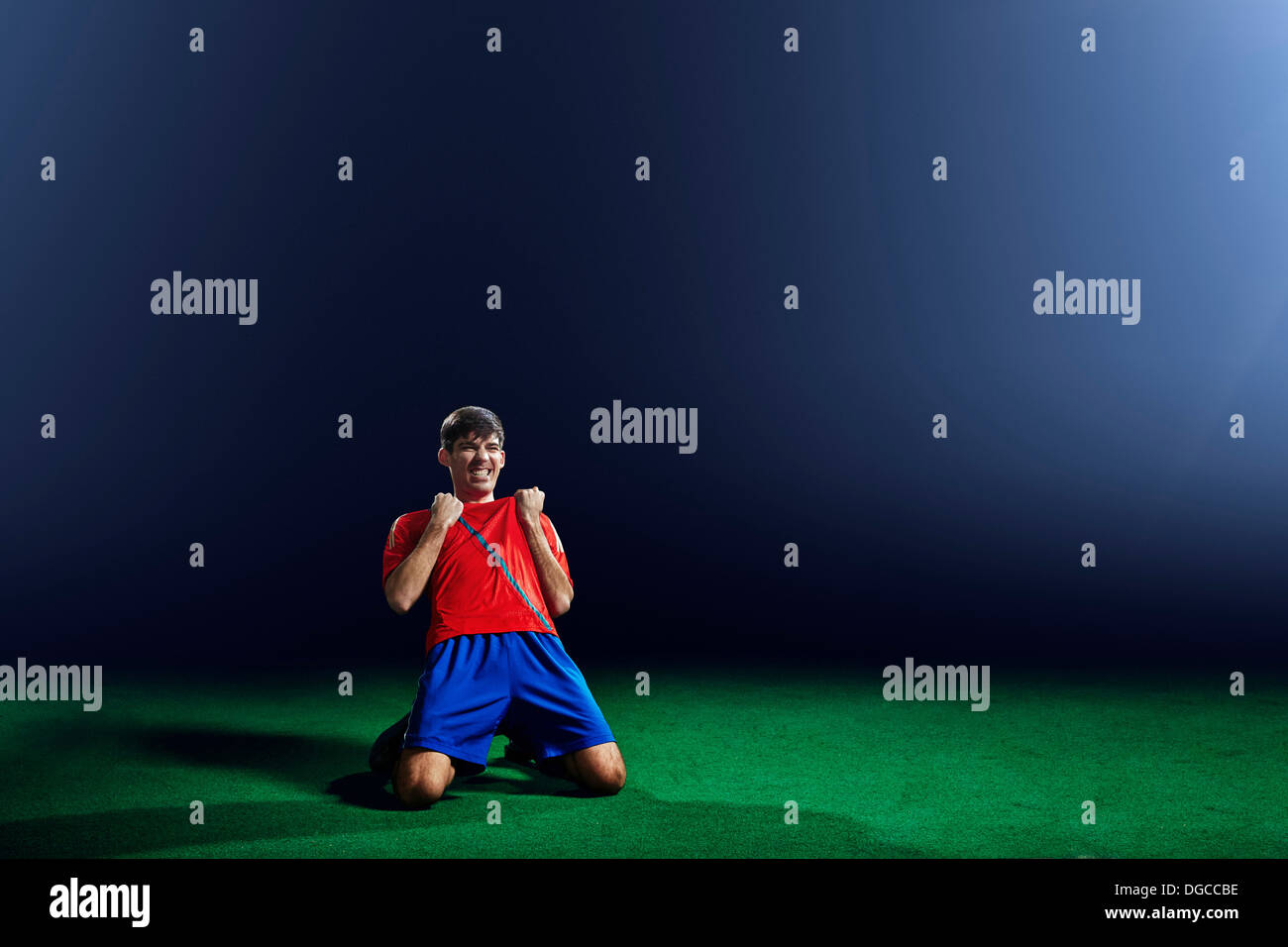 Male soccer player celebrating on knees Stock Photo