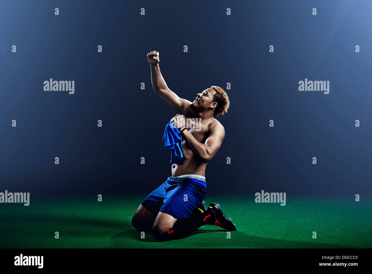 Male soccer player kneeling with arm raised Stock Photo Alamy