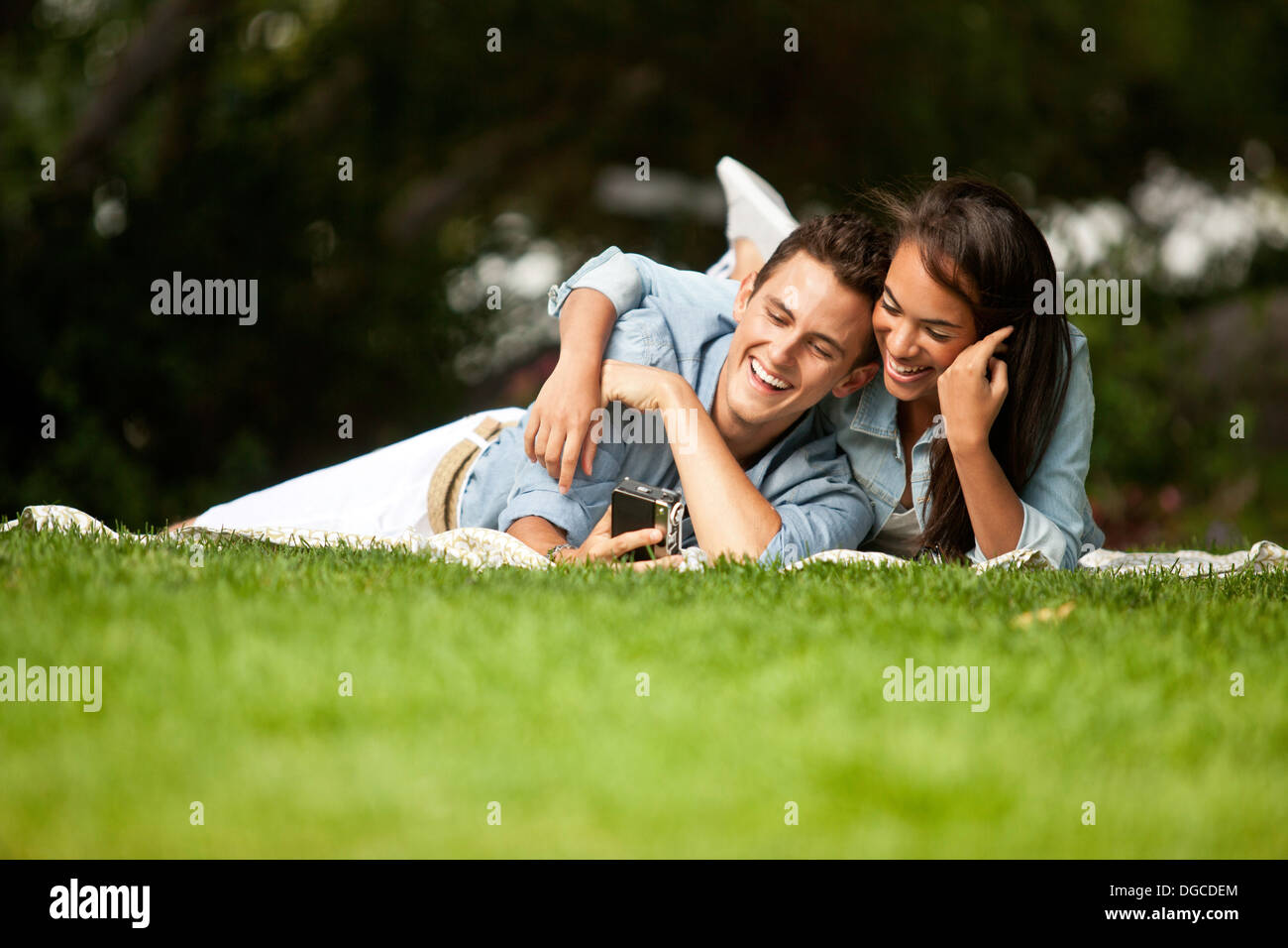 Young couple lying in park, smiling Stock Photo