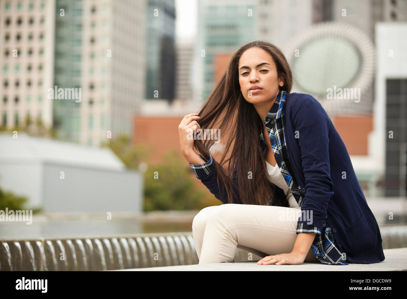 Young woman sitting in city hi-res stock photography and images - Alamy