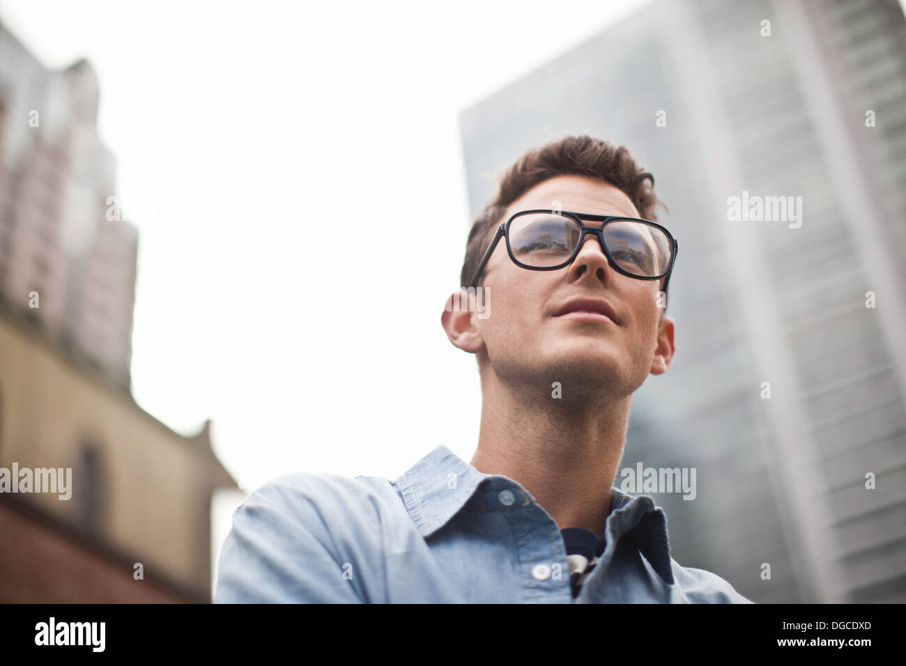 Young man in spectacles looking away, low angle view Stock Photo