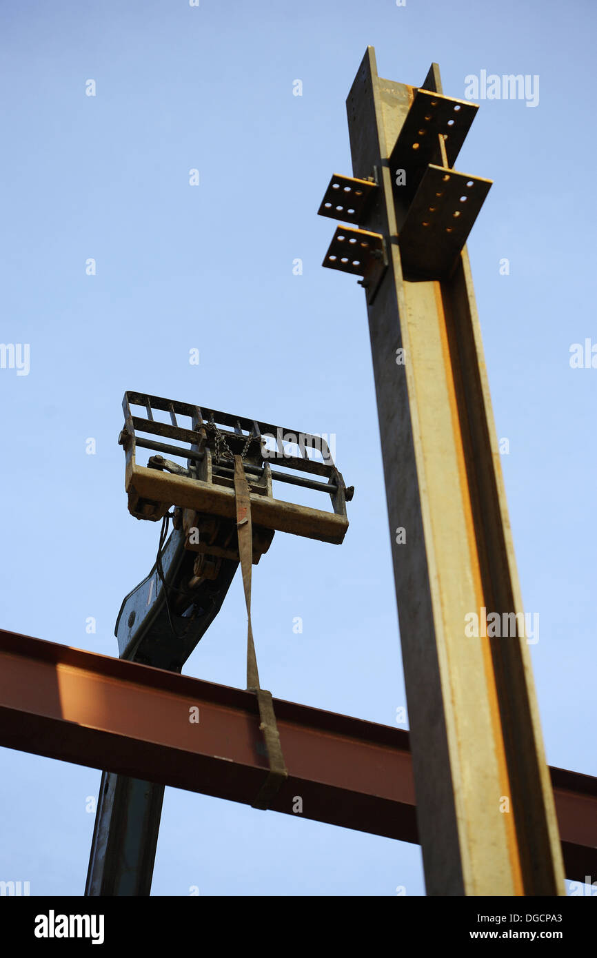 Construction steel I beams being lifted into place with construction lift Stock Photo Alamy