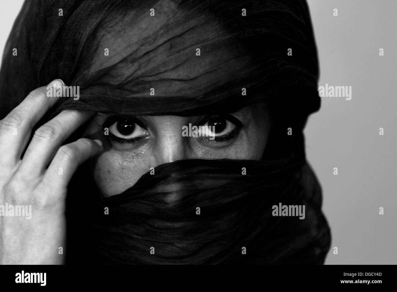 Black and white closeup of an unidentified Moroccan woman with a veil over her face so just her eyes show Stock Photo