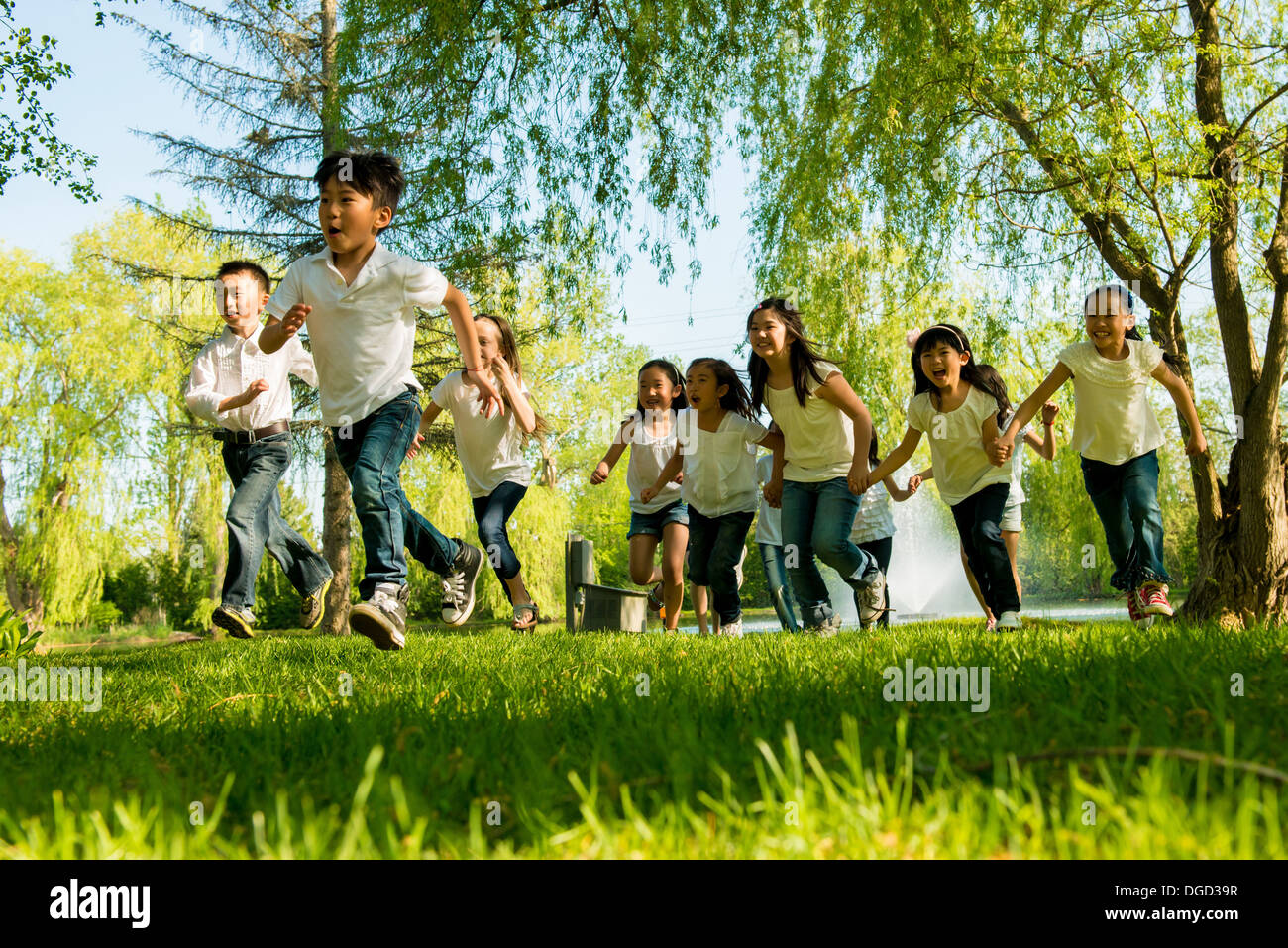 Boys and girls running in park Stock Photo