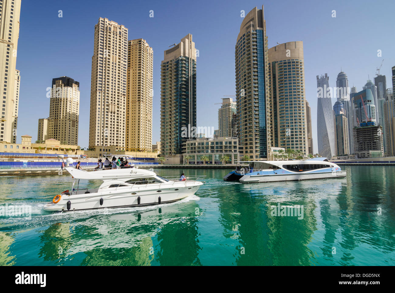 The RTA Dubai Ferry and a private boat in Dubai Marina, Dubai, UAE Stock Photo