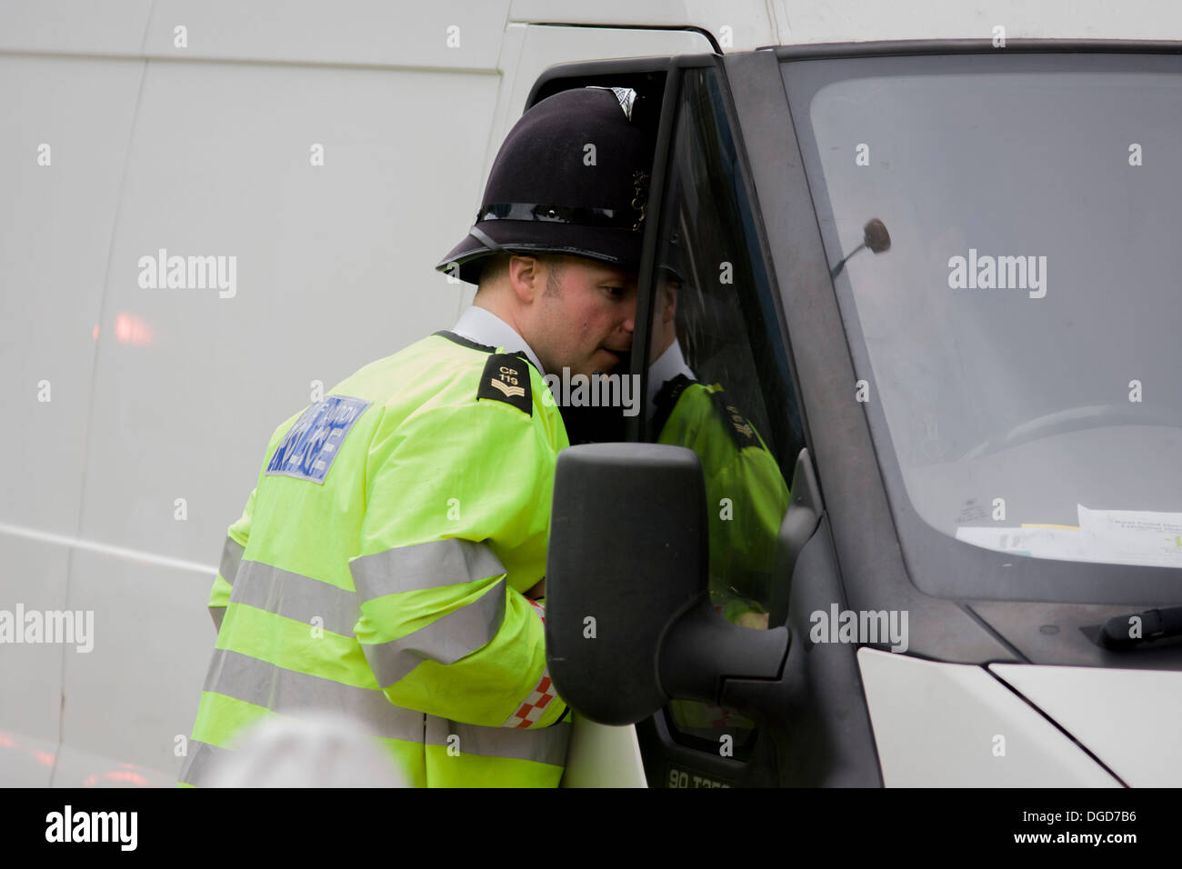 A officer from the City of London police, questions a white van driver at a checkpoint. Stock Photo